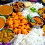 Colorful Gujarati thali with various traditional dishes.