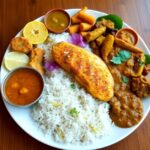 Colorful Goan thali with various traditional dishes.