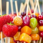 Colorful tanghulu skewers with candied fruits on display.