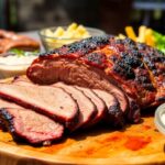 Juicy sliced brisket on a wooden platter outdoors.